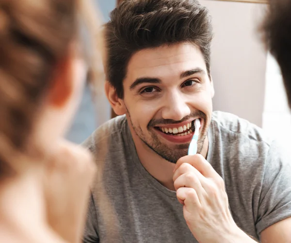 image-of-funny-couple-cleaning-teeth-together-in-b-RPP5NK5 cepillado dientes